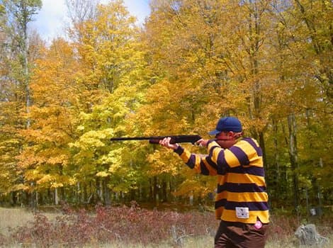 Hunter shooting in brilliant fall foliage