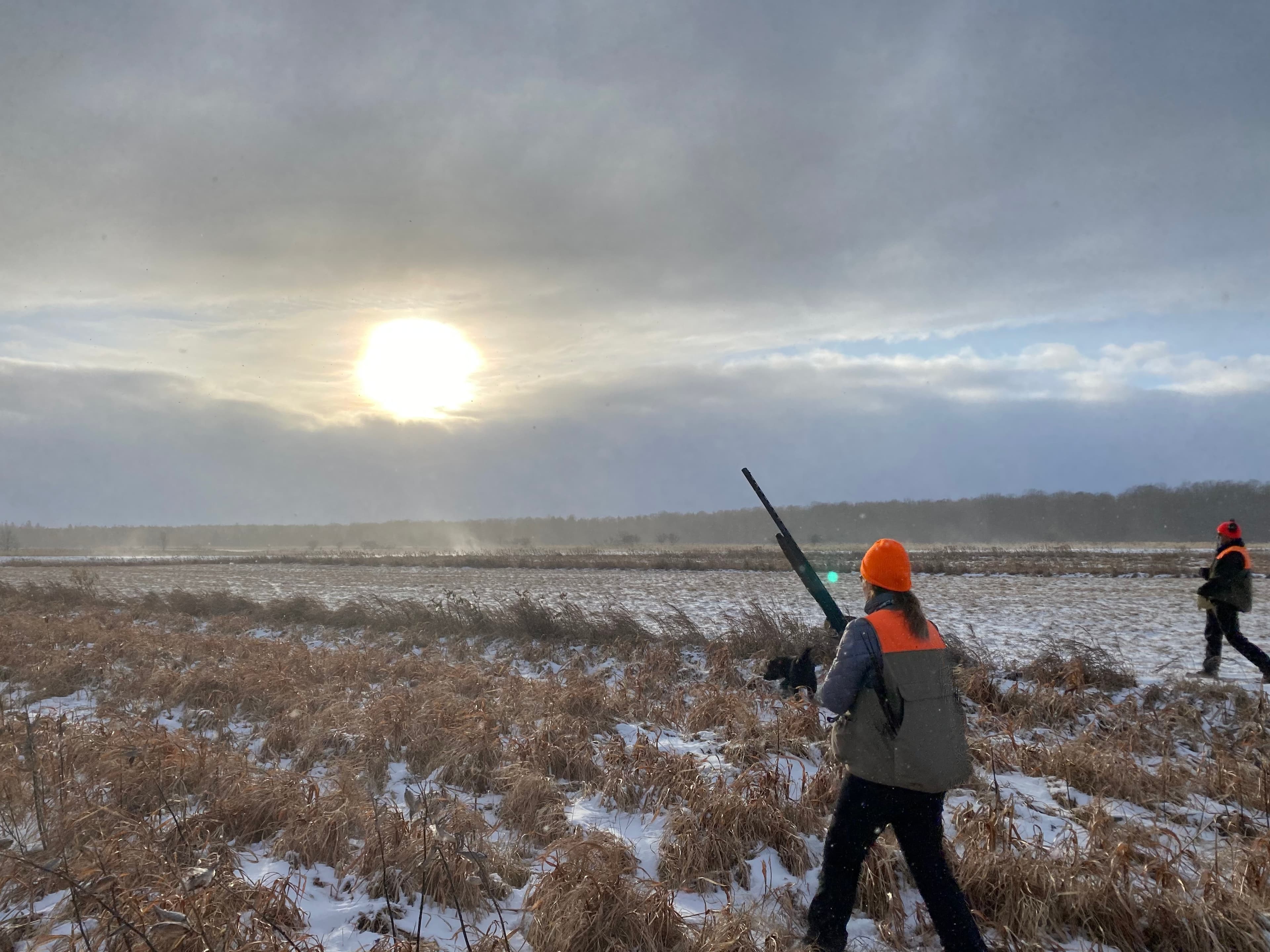 Hunters in the field at winter sunrise